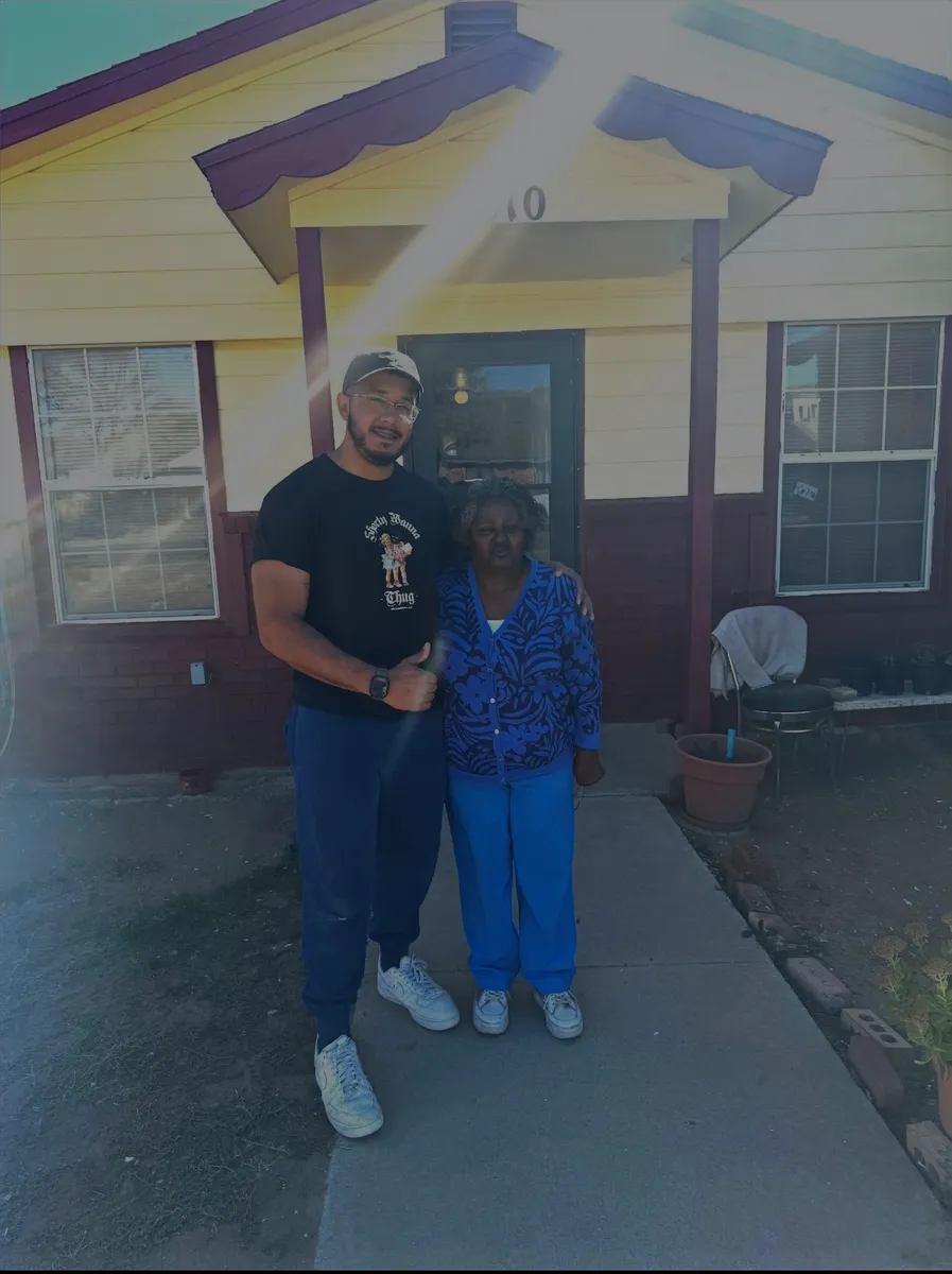 Michael with a homeowner in front of her newly painted house